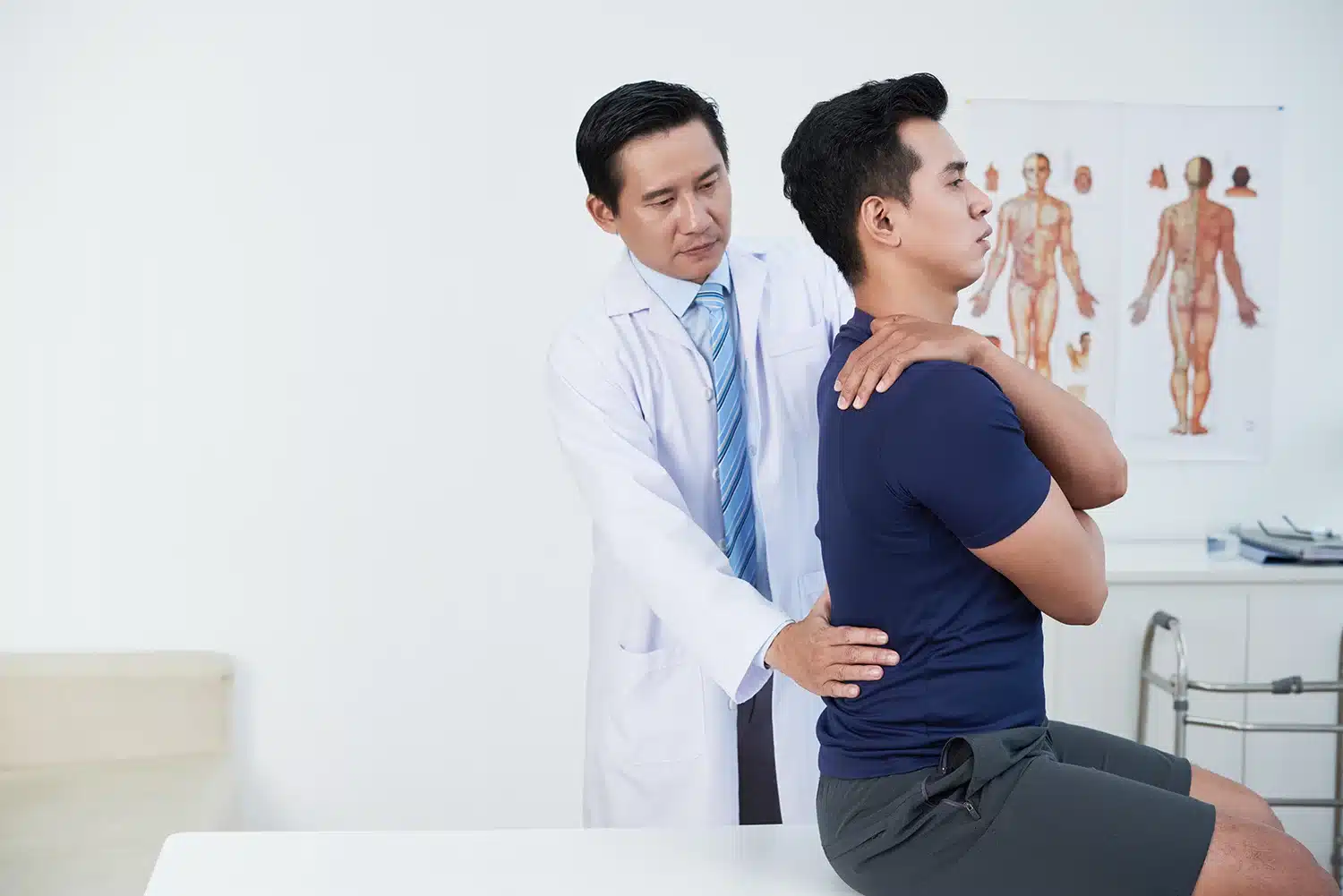 A doctor examines a patient’s lower back to help identify the cause of lower back pain A doctor examines a patient’s lower back to help identify the cause of lower back pain