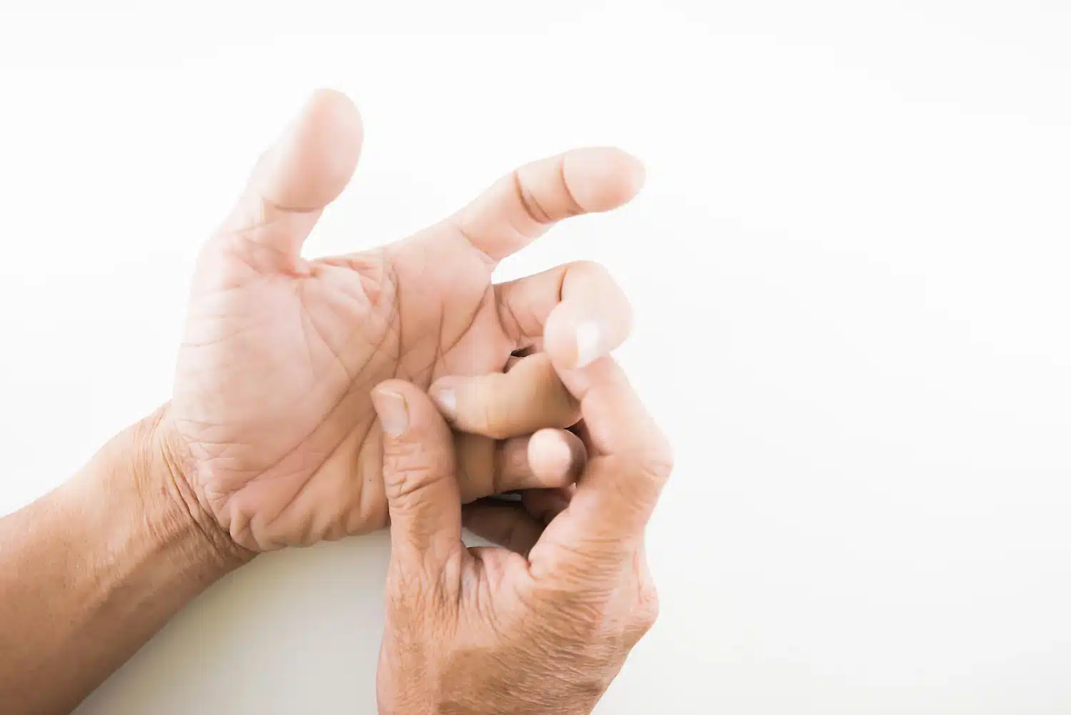 A person holds a bent and locked finger, a common sign of trigger finger A person holds a bent and locked finger, a common sign of trigger finger